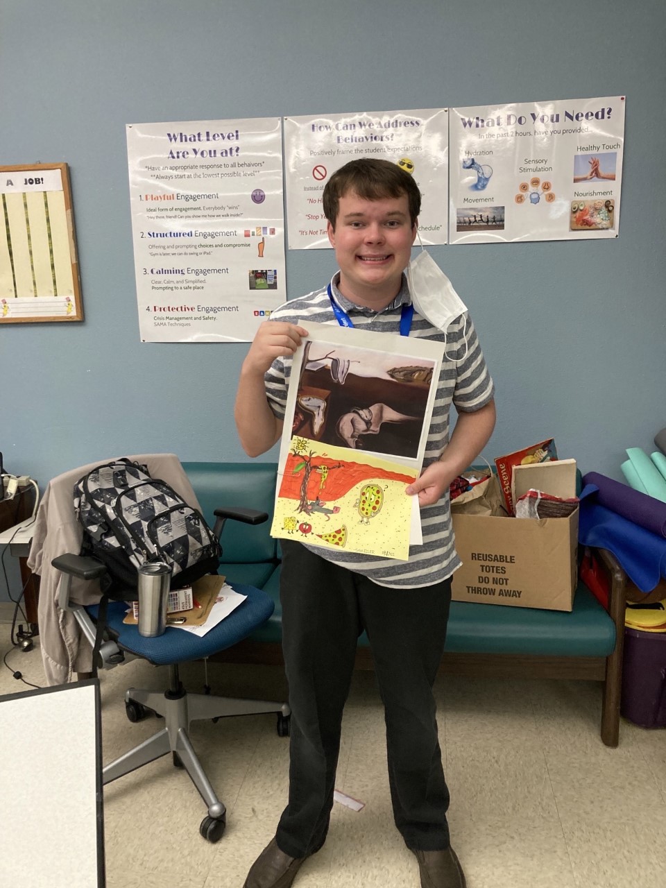 Sam Eiler poses while holding up his artwork.